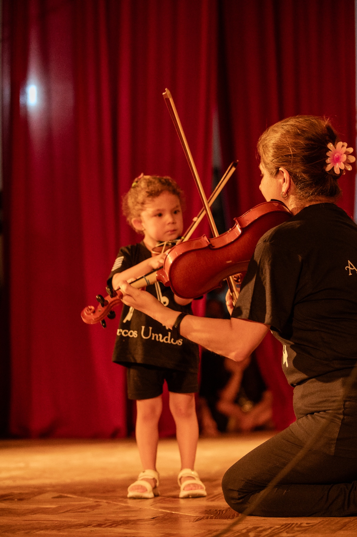 Pequeña alumna dando sus primeros pasos con el violín junto a su profesora