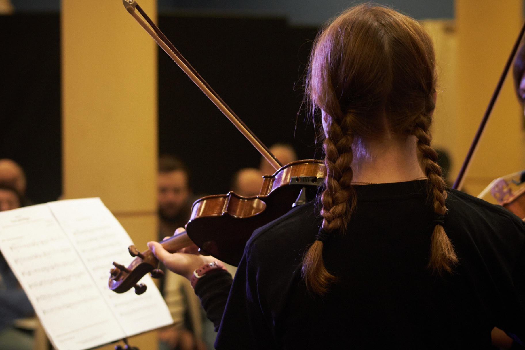 Alumna de violín concentrada durante el concierto