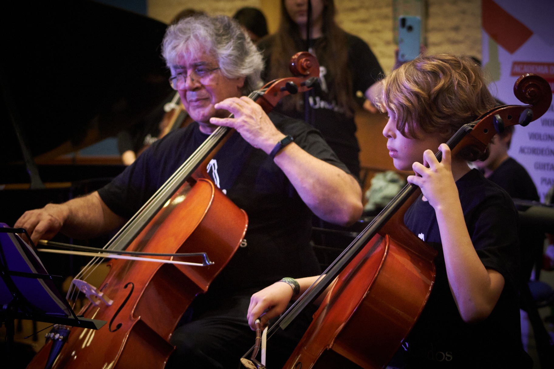 Profesor y estudiante de cello tocando juntos en concierto